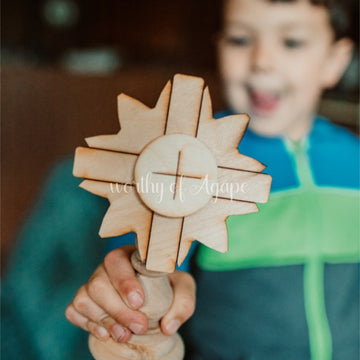 young boy plays with wooden monstrance